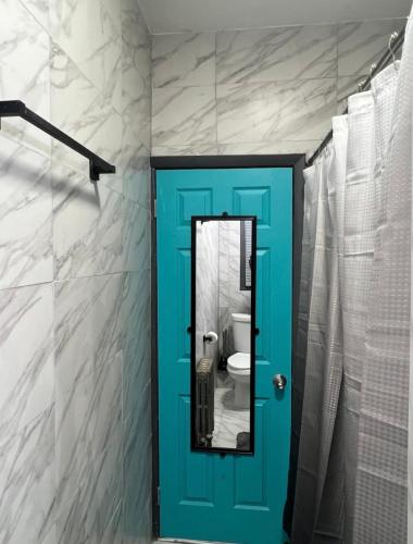 bagno con porta blu e specchio di Vintage Luxury Suites a Newark