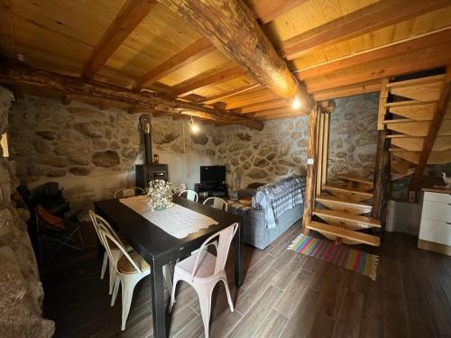 uma sala de estar com uma mesa e cadeiras e um sofá em Casa da Serra da Estrela em Gonçalo