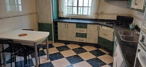 a small kitchen with a table and a sink at piso en arenas de velez malaga in Málaga