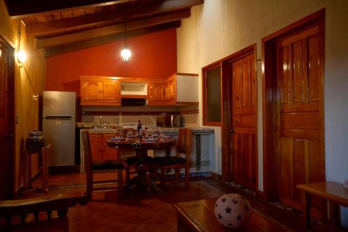 a kitchen with a table and a refrigerator at Hotel Villas San Miguel in Pátzcuaro