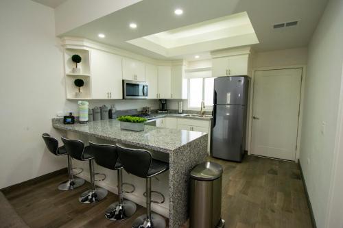 a kitchen with a counter with stools and a refrigerator at Residence 35 in Puerto Peñasco