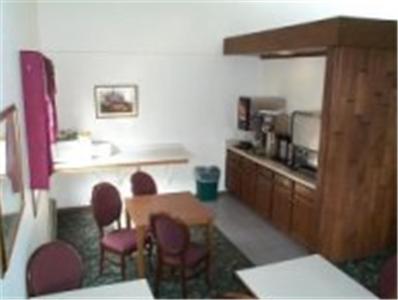 Habitación con sillas, mesa y cocina. en American Motel Waseca, en Waseca
