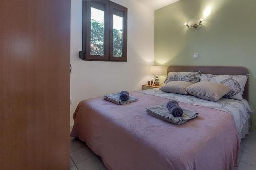 a bedroom with a bed with two towels on it at Poolside compact family cottage Lea in Rovinjsko Selo