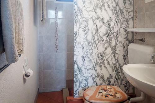 een badkamer met een douche, een toilet en een wastafel bij Poolside compact family cottage Lea in Rovinjsko Selo