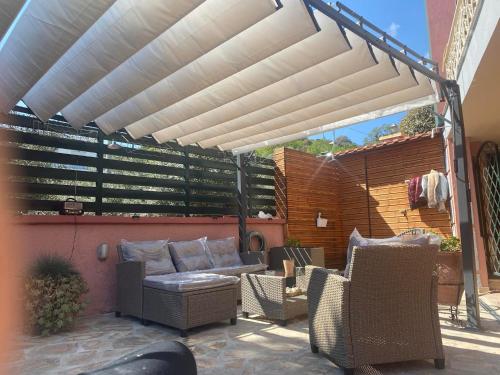 a patio with a couch and chairs under a pergola at OCEANIδES in Kavála