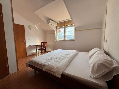Schlafzimmer mit einem Bett, einem Fenster und einem Tisch in der Unterkunft Villa KiWi in the Heart of Ohrid in Ohrid