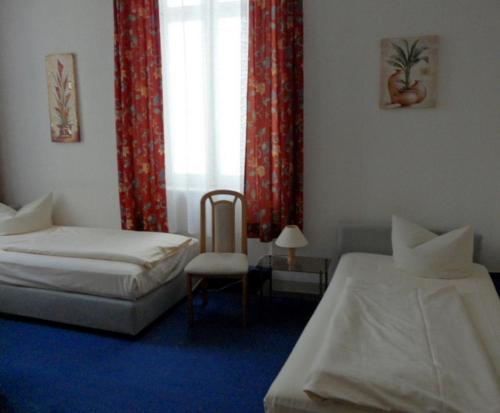 um quarto com 2 camas e uma janela com cortinas vermelhas em Gästehaus Vis-A-Vis em Rüdesheim am Rhein