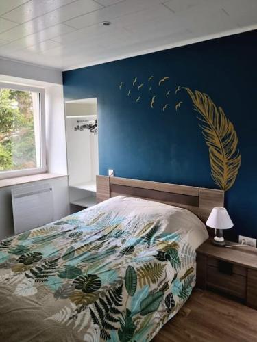 1 dormitorio con 1 cama con pared azul en Appartement chaleureux 80m2, en Orbey