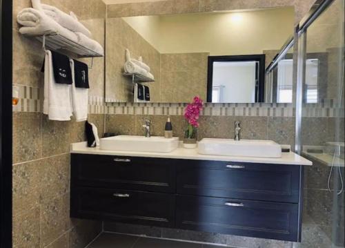 a bathroom with two sinks and a mirror at Just like home Vacation in Ocho Rios