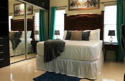 a bedroom with a large bed and a large mirror at Just like home Vacation in Ocho Rios