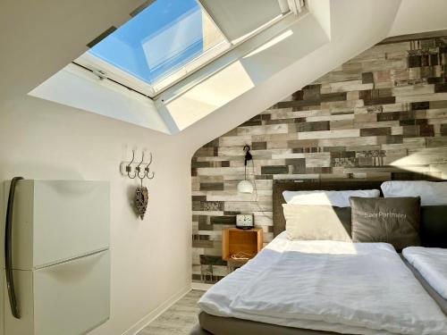 a bedroom with a bed and a skylight at Living at Saarpartments - Business & Holiday Apartments with Netflix for Long- and Short term Stay, 3 min to St Johanner Markt and Points of Interest in Saarbrücken