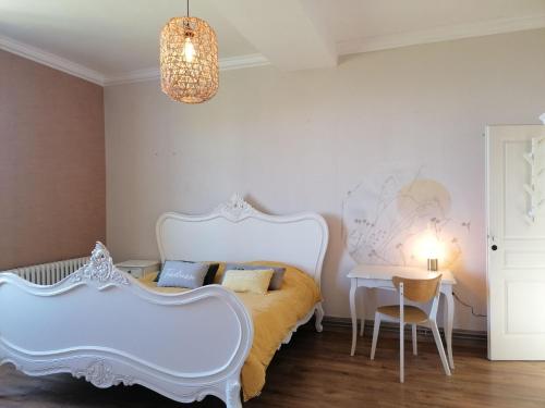 1 dormitorio con cama blanca y mesa en Monchâteau étoilé, Chambres d'Hôtes, en Merlas