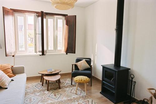 uma sala de estar com um fogão e um sofá em Casa das Termas - Cabeço de Vide em Cabeço de Vide