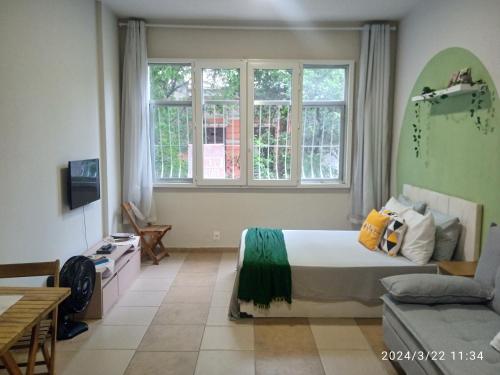 1 dormitorio con cama, sofá y ventanas en Lapa - acomoda até 4 pessoas, en Río de Janeiro