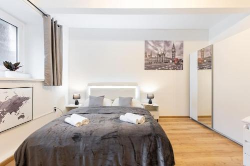 a bedroom with a large bed with white walls at Central Serenity: Urban Garden Retreat in Bratislava