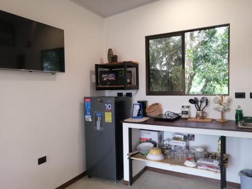 a kitchen with a refrigerator and a counter and a window at Villa Buenaventura in San Ramón