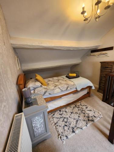 a bedroom with a bed and a tv and a rug at East Cote Cottage in Settle