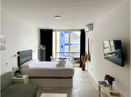 um quarto branco com uma cama e um sofá em Inviting Studio with Sea View em Torremolinos