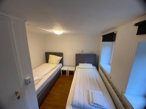 een kleine kamer met 2 bedden en een raam bij Monteurwohnungen direkt am Hauptbahnhof in Neumünster