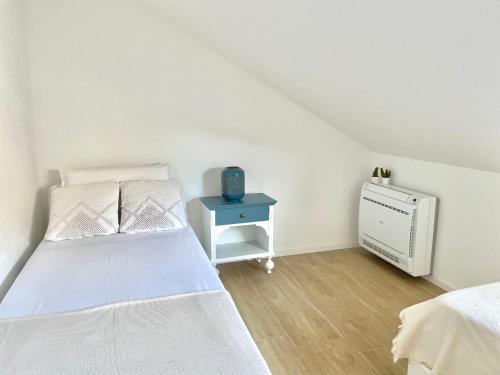 um quarto branco com uma cama e uma mesa de cabeceira em La Casina Del Mare em Cervia