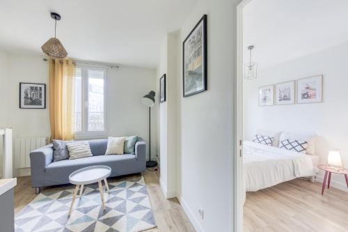 Joli appartement 8min de Paris! في روسني-سو-بوا: غرفة معيشة مع أريكة زرقاء وسرير