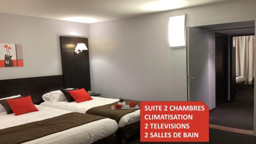 a hotel room with two beds with red pillows at Hôtel Alliance in Lourdes