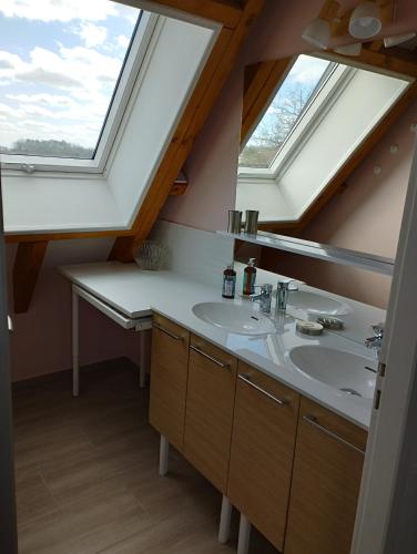 une salle de bain avec deux lavabos et deux fenêtres dans l'établissement Gite en Périgord proche de Lascaux, à Rouffignac-Saint-Cernin-de-Reilhac