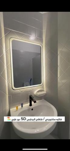 a bathroom with a mirror and a white sink at لافونتين بردايس in Durat  Alarous