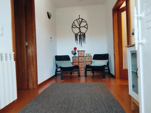 a living room with three chairs and a clock on the wall at Casa Campo ao Rio_Village in Barcelos
