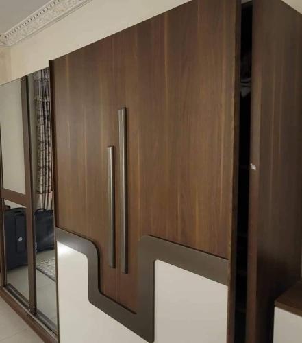 uma porta de madeira num quarto com um espelho em Hageb 
