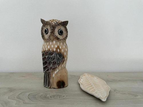 a wooden figurine of two owls sitting on a table at Moderno e Confortevole Appartamento, Wi-Fi e Parcheggio Gratuito in Sanluri