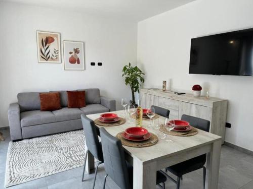 een woonkamer met een tafel en een bank bij Moderno e Confortevole Appartamento, Wi-Fi e Parcheggio Gratuito in Sanluri