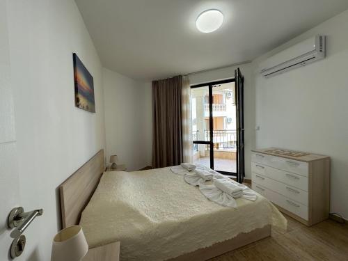 a bedroom with a bed and a dresser and a window at HORIZON 12 'A' APARTMENT Sveti Vlas in Sveti Vlas
