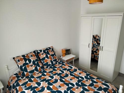 une chambre avec un lit et un miroir dans l'établissement Gite du vieux chêne, à Reignac