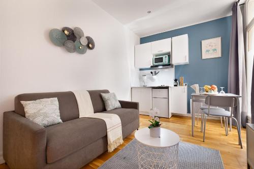 un salon avec un canapé et une table dans l'établissement Guestrust - Arc de Triomphe 46, à Paris