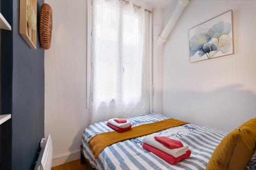 une petite chambre avec un lit avec des serviettes dessus dans l'établissement Guestrust - Arc de Triomphe 46, à Paris