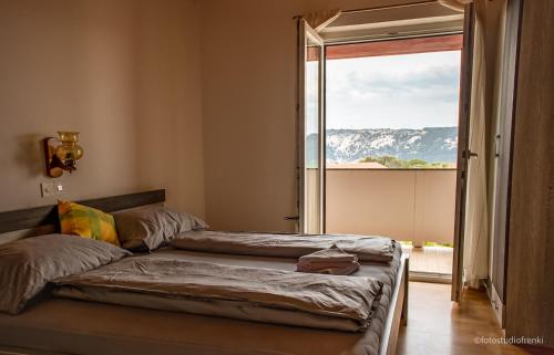 two beds in a room with a large window at Guesthouse Marija II in Lopar