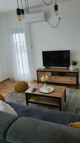 a living room with a tv and a coffee table at JR Lux apartman in Stara Pazova