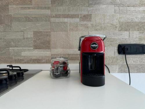 a red toaster sitting on a counter next to a stove at Moderno e Confortevole Appartamento, Wi-Fi e Parcheggio Gratuito in Sanluri