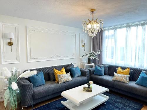 a living room with a couch and a chandelier at Stunning Flat: Near Wembley Stadium! in London