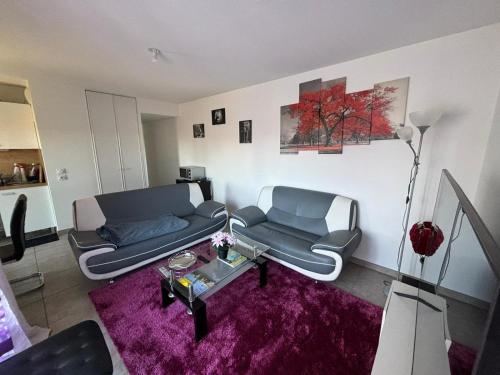 sala de estar con 2 sofás y alfombra morada en Chic Appart LYON - Chambre chez l'habitant, en Saint-Fons