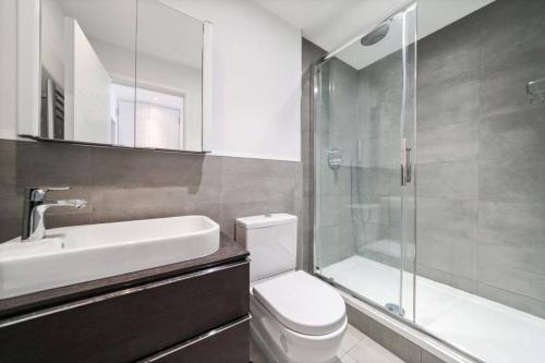 a bathroom with a toilet and a sink and a shower at Modern Flat in Camden Town in London