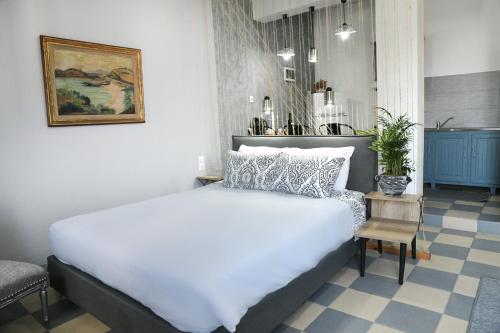 ein Schlafzimmer mit einem großen weißen Bett und einem Stuhl in der Unterkunft Panorama Studios & Apartments in Myrties