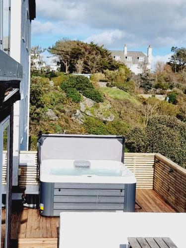a cooler sitting on a deck with a view of a house at Carnedd - Trearddur Bay - Stanley-Stays in Trearddur