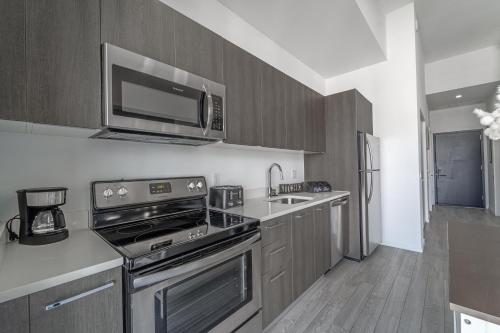 a kitchen with a stove and a microwave at TR Miami 2 Bedroom, 1 Bedroom, and Studio Condos with Balconies in Miami