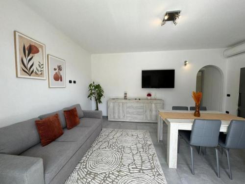 SanluriにあるModerno e Confortevole Appartamento, Wi-Fi e Parcheggio Gratuitoのリビングルーム(ソファ、テーブル付)