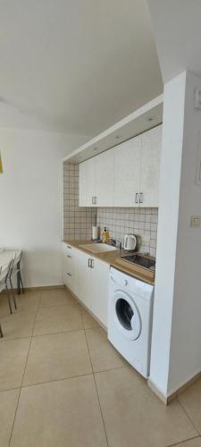 uma cozinha com um lavatório e uma máquina de lavar roupa em Suite on the Bat Yam seashore em Bat Yam