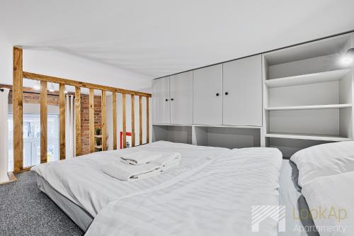 ウッチにあるU Fabrykanta by LookApのベッドルーム1室(白いシーツが備わるベッド2台付)