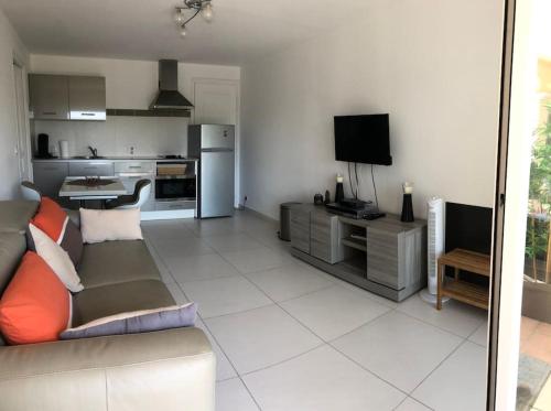 un salon avec un canapé et une cuisine dans l'établissement Studio à ESTEREL BELAHOME, à Saint-Raphaël