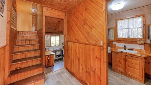 a bathroom with wood paneling and a sink and a counter at Crayfish Creek Van & Cabin Park in Crayfish Creek